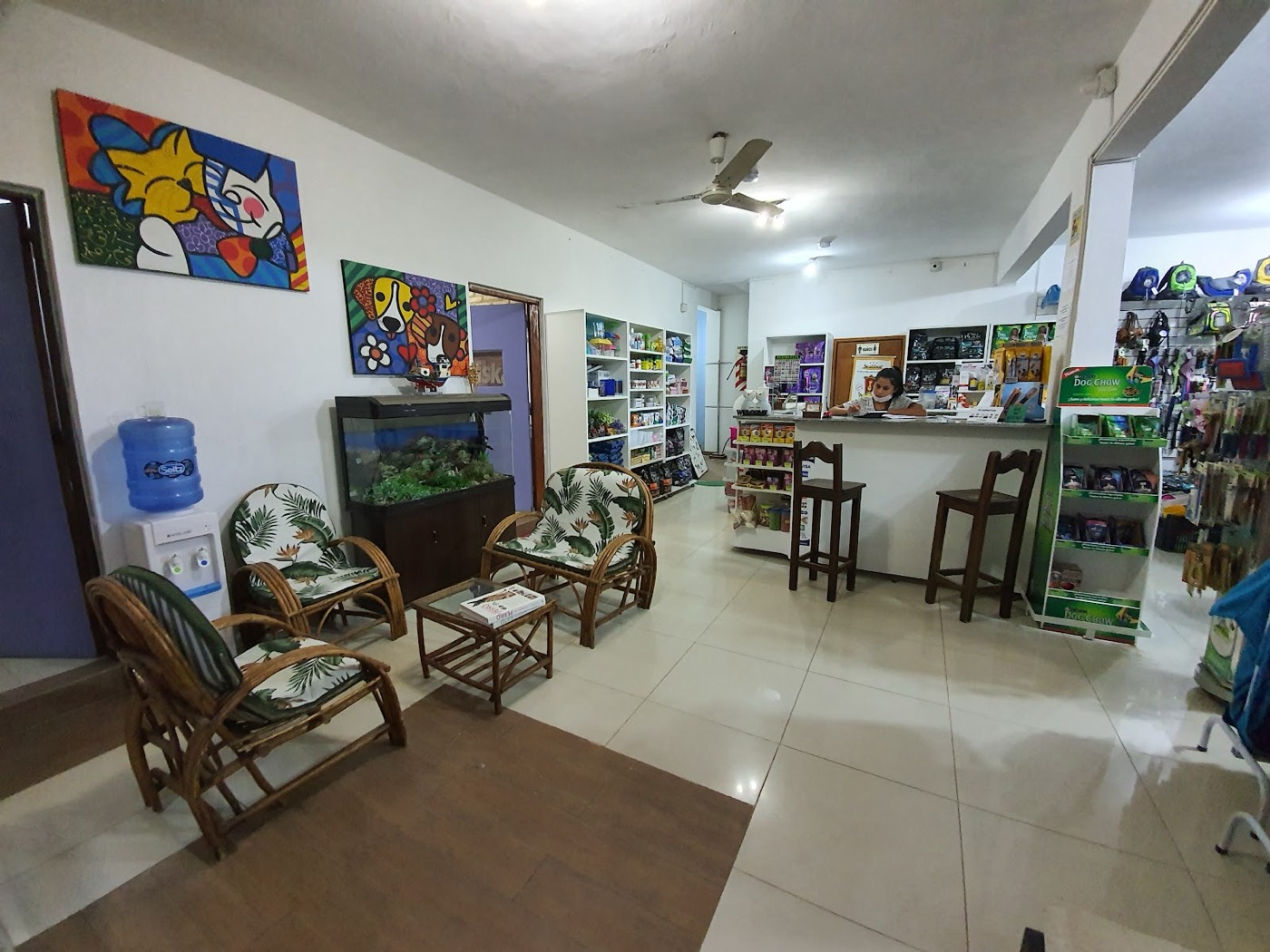 Sala de espera de la clínica, con sillones, una pecera y la tienda al fondo